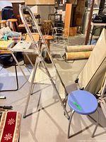 Side view of aluminum ladder and blue stool