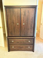 Front view of closed armoire showing two doors and two drawers