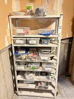 full shelving unit with multiple clear bins containing various hardware
