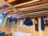 Overall view of five bagged chairs and four tripod stools hanging from ceiling