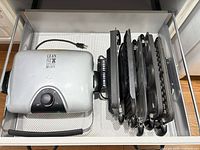 Grill base and stacked interchangeable plates in drawer