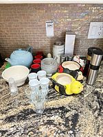 All items grouped on countertop showing teapot, cups, grinders, glassware