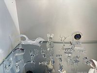 Shelf view showing entire lot of crystal figurines and clock