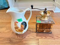 Ceramic rooster pitcher beside wood and brass manual coffee grinder