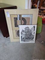 Both framed prints leaning against dresser showing size comparison