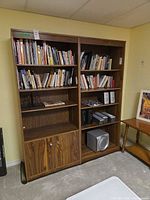 Front view of both bookcases side by side with shelves and cabinet visible