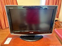 Front view of Sharp Aquos LC-20D42U TV on stand