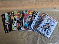 Spread of approximately 30 independent comic books, bagged and boarded