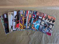 Front view showing a fanned stack of approximately thirty independent comic books, no Marvel or DC visible