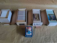 Overview of four open card boxes and one sealed blue box
