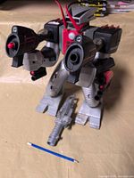 Front view of Commandobot 3 robot with cannon and pencil for scale