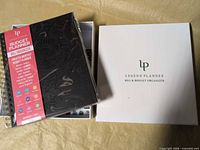 Box with planner inside: white lp Legend Planner lid and wrapped planner visible