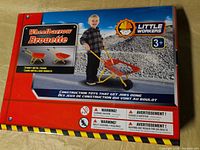 Front of box showing Little Workers kids wheelbarrow toy, age 3+