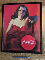 Front view of framed Coca-Cola girl print with pencil for scale