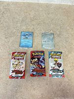 Group shot of 3 sealed fun packs plus 2 sleeved holo singles