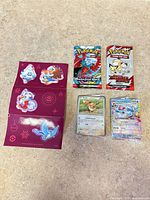 Full lot showing both sealed packs, two sleeved cards, folded sticker sheet