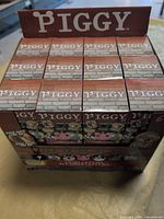 Front view of sealed retail display box marked Piggy containing 24 boxes