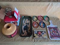 All items laid out: rectangular tray, five round trays, square tray, cutting board, mug in box, lamp base