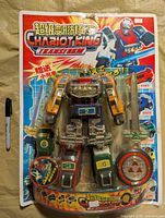 Full view of sealed Chariot King Transform robot on blister card with marker for scale