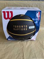 Front view of basketball in original Wilson box showing Toronto Raptors branding