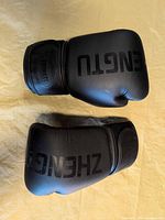 Top view of both black ZHENGTU boxing gloves showing overall condition