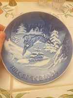 Front of plate showing blue and white snowy forest scene with leaping deer and raised lettering