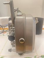 Left side profile showing housing, focus knob, mounting points