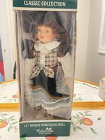 Front of boxed doll showing branding and doll attire