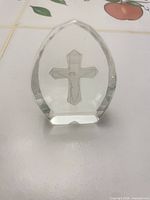 front view of faceted crystal paperweight showing crucifix inside