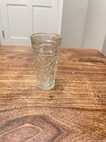 Side view of clear pressed glass shot glass showing diamond-quilted pattern