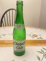 Front view of green glass Clicquot Club bottle with label