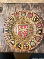 Front view of painted wooden wall plate with Frankfurt crest and surrounding city arms