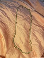 Full view of entire necklace laid flat showing multi-strand design and ring connectors