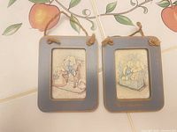 Front view showing both blue-gray framed bunny plaques with twine hangers