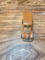 Front view showing brown roof, orange fenders, V-shaped grille, exposed chrome engine, paint chips