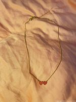 Full view of gold-tone necklace laid flat showing chain and pendant