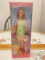 Front view of boxed Flower Shop Barbie doll with accessories visible