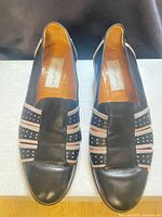 Top view of both loafers showing leather uppers, fabric accents, and insoles