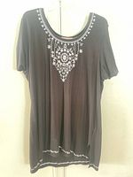 Front view of black tunic displaying embroidery and overall condition