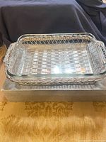 Glass casserole dish nested in silver lattice basket on top of box