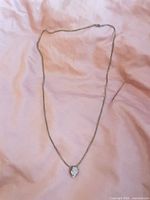 Full view of necklace laid flat showing chain length and pendant