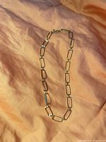 Full view of silver-tone rectangular link necklace laid flat