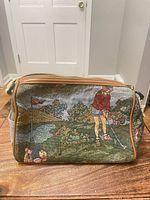 Front view showing golf scene tapestry, piping, zipper