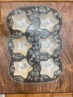 Top view of the baking tray showing six star compartments, floral design and beaded rim