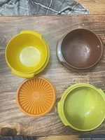 Top view showing yellow, brown, green bowls and orange lid