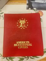 Front of red binder with gold Liberty Bell and text