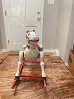 Front view of wooden rocking horse on red rockers