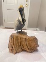 Front view of carved bird on wood base