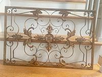 full view of rectangular wrought iron wall art panel on stairs