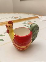 Front angled view showing rooster head, body coloration and candle opening